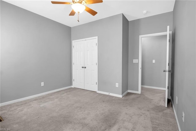 unfurnished bedroom with ceiling fan, a closet, and light colored carpet