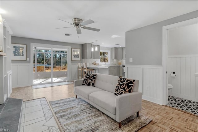 living room featuring light parquet floors and ceiling fan