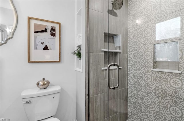 bathroom with an enclosed shower and toilet