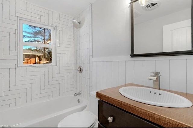 full bathroom with vanity, tiled shower / bath combo, and toilet