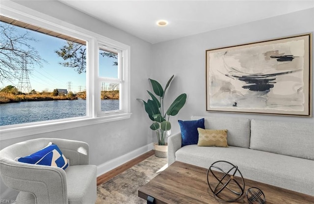 sitting room featuring a water view and hardwood / wood-style flooring