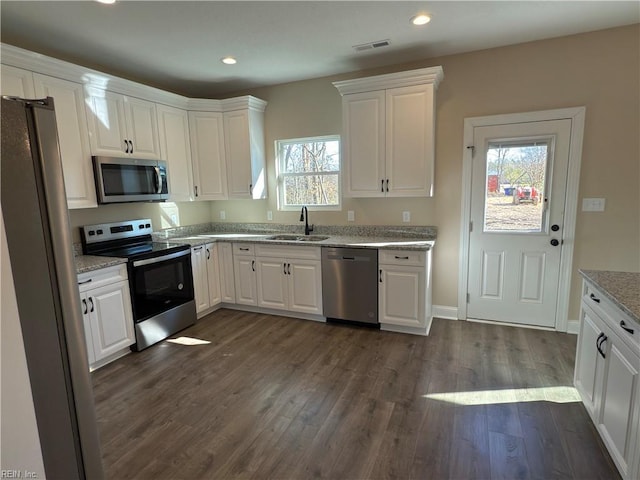 kitchen with plenty of natural light, white cabinetry, sink, and appliances with stainless steel finishes