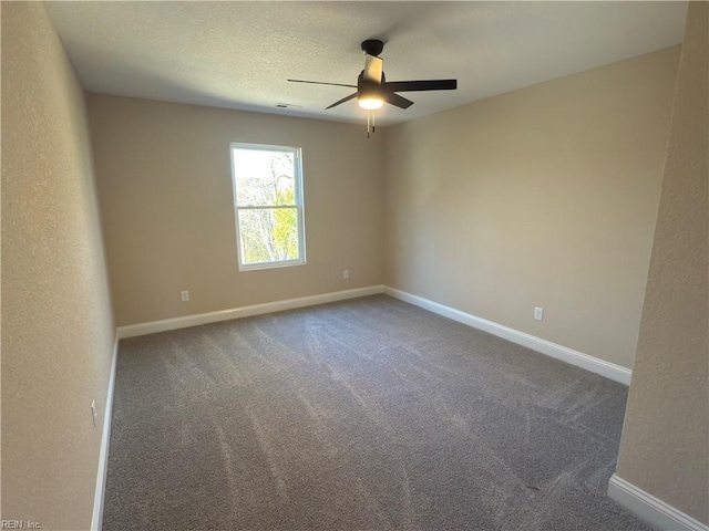 unfurnished room with ceiling fan and dark carpet