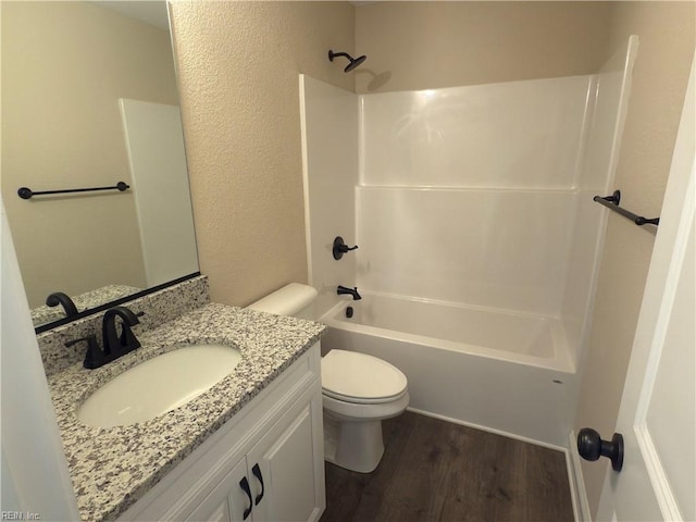 full bathroom featuring hardwood / wood-style floors, vanity, toilet, and shower / washtub combination