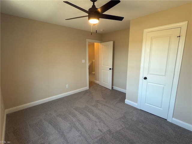 unfurnished bedroom with ceiling fan and dark carpet