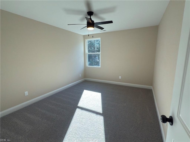 empty room featuring ceiling fan and dark carpet