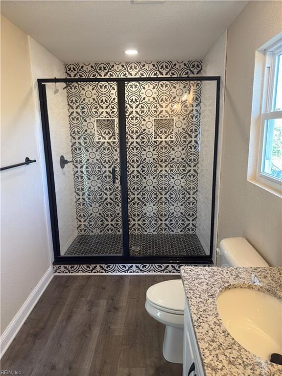 bathroom featuring walk in shower, hardwood / wood-style floors, vanity, and toilet