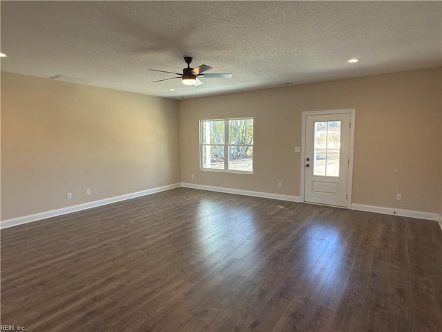 spare room with ceiling fan, dark hardwood / wood-style floors, and a textured ceiling