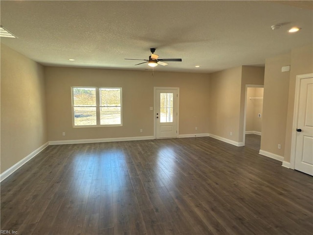 spare room featuring a textured ceiling, ceiling fan, and dark wood-type flooring