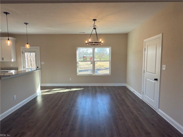 unfurnished dining area with a notable chandelier and dark wood-type flooring