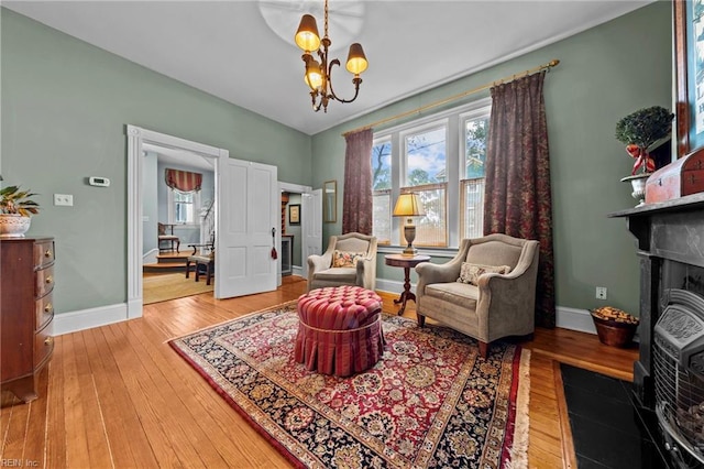 living area with hardwood / wood-style floors and an inviting chandelier