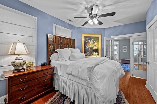 bedroom with ceiling fan, hardwood / wood-style floors, and french doors