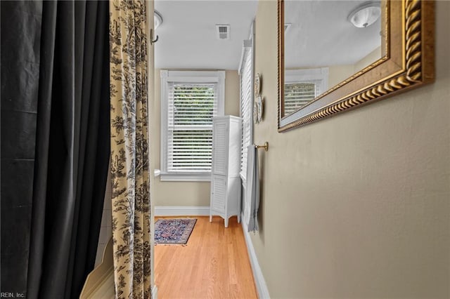 corridor with hardwood / wood-style flooring