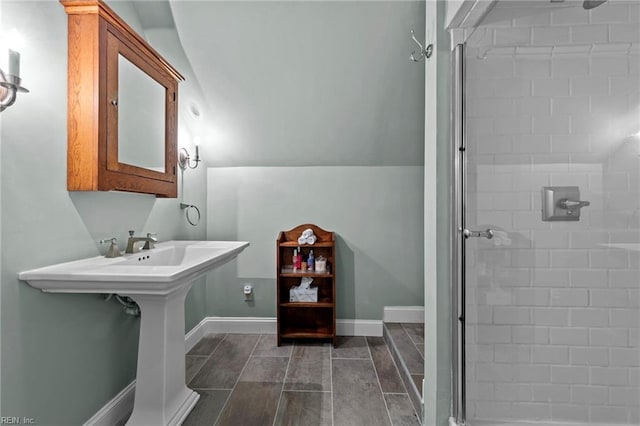 bathroom with tiled shower and vaulted ceiling