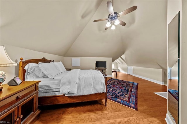 bedroom featuring hardwood / wood-style floors, ceiling fan, and lofted ceiling