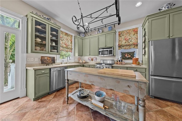 kitchen featuring plenty of natural light, sink, appliances with stainless steel finishes, and green cabinetry