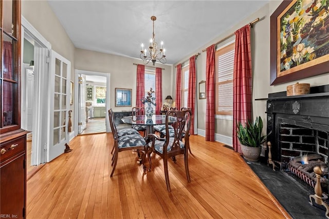 dining area with a chandelier and light hardwood / wood-style flooring