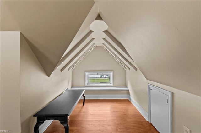 bonus room with light wood-type flooring and vaulted ceiling