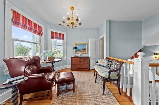 living area with wood-type flooring and an inviting chandelier