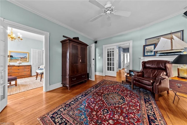 living area with french doors, ceiling fan with notable chandelier, crown molding, and wood-type flooring