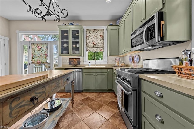 kitchen with a chandelier, sink, stainless steel appliances, and green cabinetry