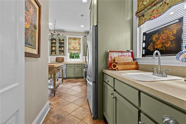 kitchen with sink, an inviting chandelier, green cabinets, decorative light fixtures, and light tile patterned floors