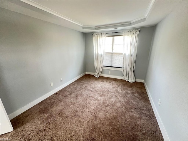 empty room featuring carpet flooring, a tray ceiling, and crown molding