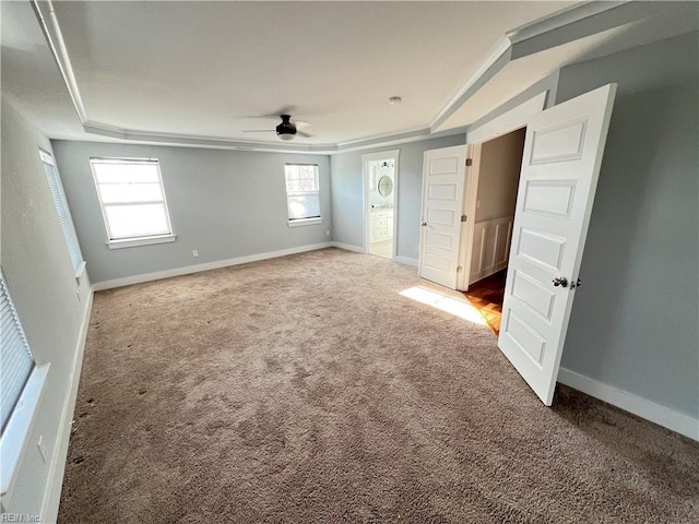 unfurnished bedroom with carpet, ceiling fan, ornamental molding, and a tray ceiling