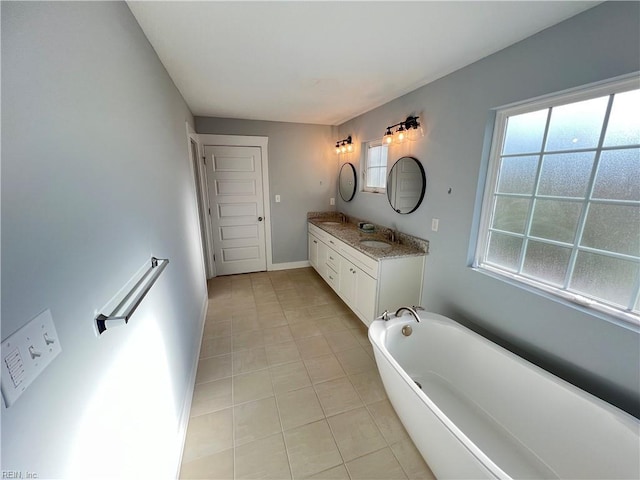 bathroom with tile patterned floors, vanity, and a tub to relax in