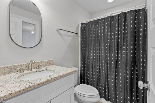 bathroom with a shower with shower curtain, vanity, and toilet