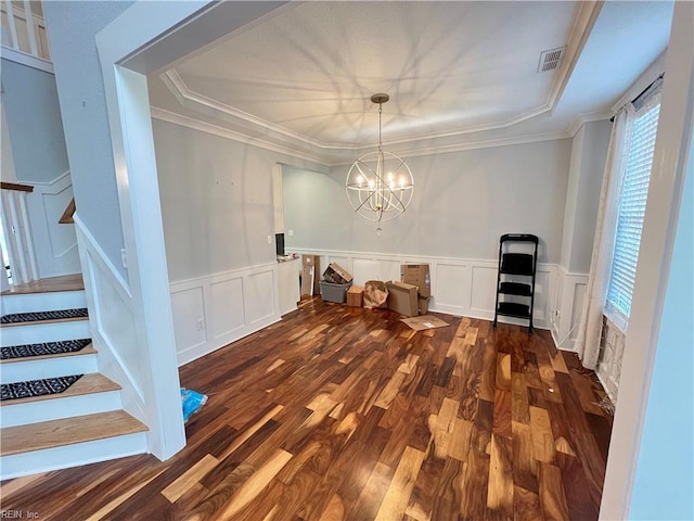 unfurnished dining area featuring crown molding, dark hardwood / wood-style flooring, and a notable chandelier