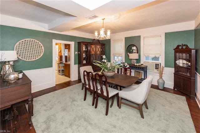 dining area with dark hardwood / wood-style flooring, a tray ceiling, an inviting chandelier, and cooling unit