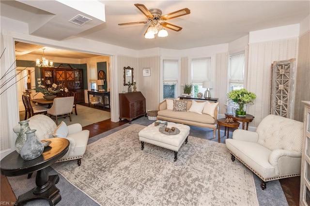 living room featuring dark wood-type flooring and ceiling fan with notable chandelier