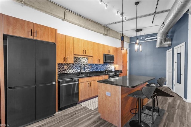 kitchen featuring sink, hanging light fixtures, stainless steel appliances, dark hardwood / wood-style floors, and a kitchen island