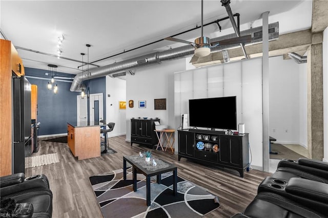 living room featuring ceiling fan and dark hardwood / wood-style floors