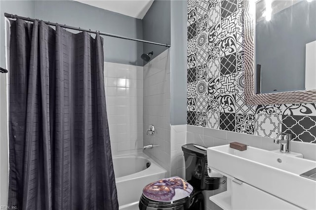 full bathroom featuring decorative backsplash, sink, shower / bath combo with shower curtain, and toilet