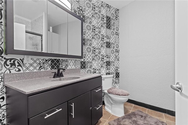 bathroom with toilet, vanity, and tile patterned floors