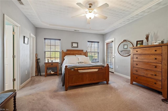 bedroom featuring light carpet, a raised ceiling, and ceiling fan