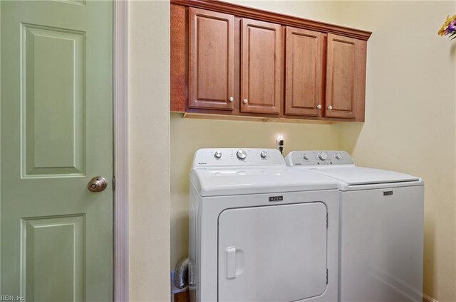 laundry area with washer and dryer and cabinets