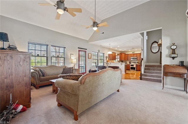 living room featuring ceiling fan, high vaulted ceiling, and light colored carpet