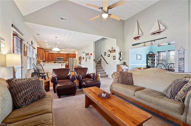 carpeted living room with ceiling fan and lofted ceiling