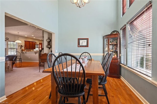 dining area featuring light wood-type flooring and an inviting chandelier