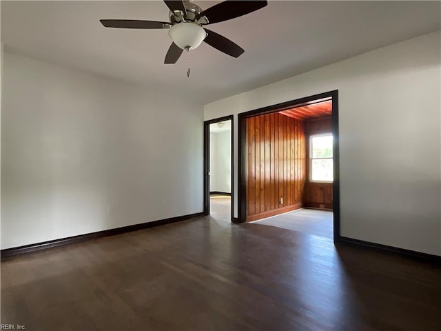 empty room with ceiling fan and dark hardwood / wood-style floors