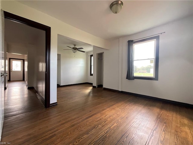 spare room featuring a wealth of natural light, dark wood-type flooring, and ceiling fan