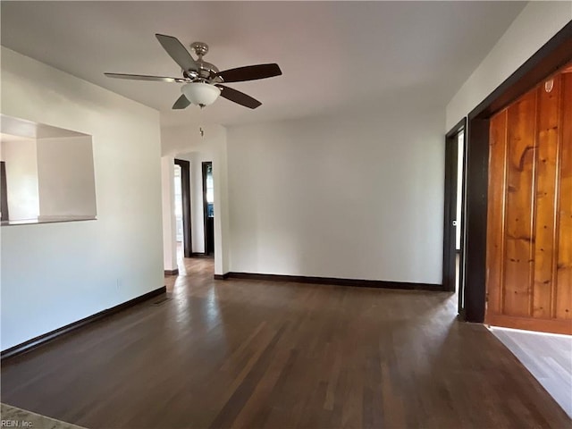 unfurnished room with ceiling fan and dark wood-type flooring