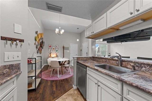 kitchen featuring white cabinetry, sink, a notable chandelier, pendant lighting, and a textured ceiling