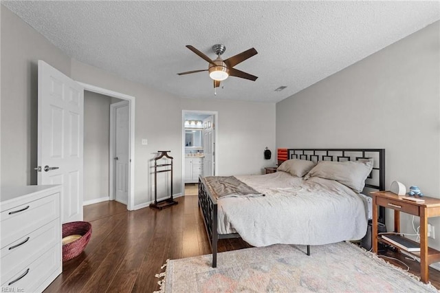 bedroom with connected bathroom, ceiling fan, dark hardwood / wood-style flooring, and a textured ceiling