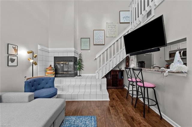 living room featuring dark hardwood / wood-style floors and a tiled fireplace