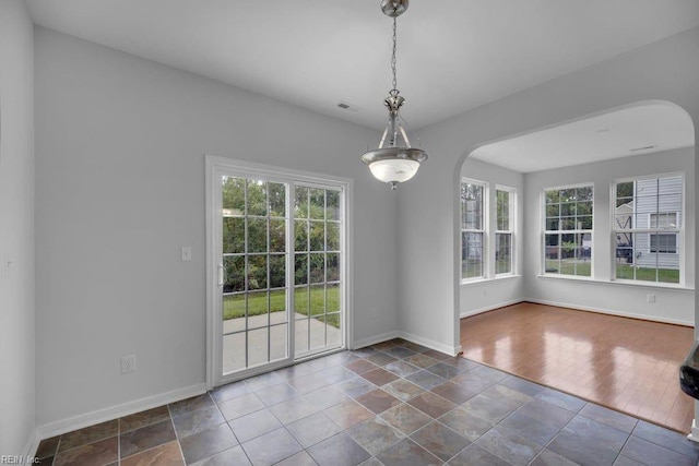 unfurnished dining area with dark tile patterned flooring