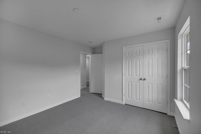 unfurnished bedroom with a closet and carpet floors